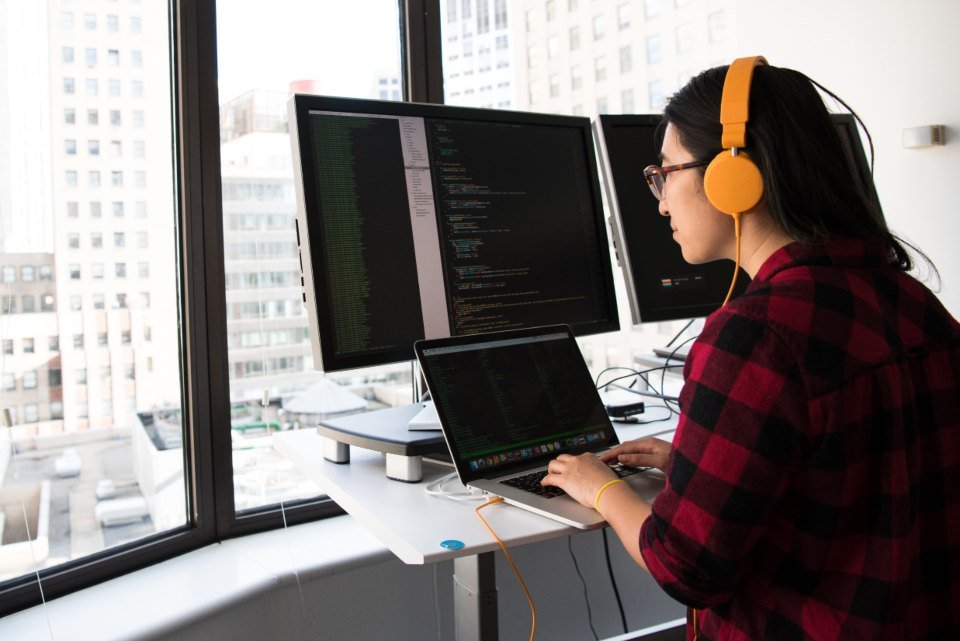 Developer working across two monitors and a laptop