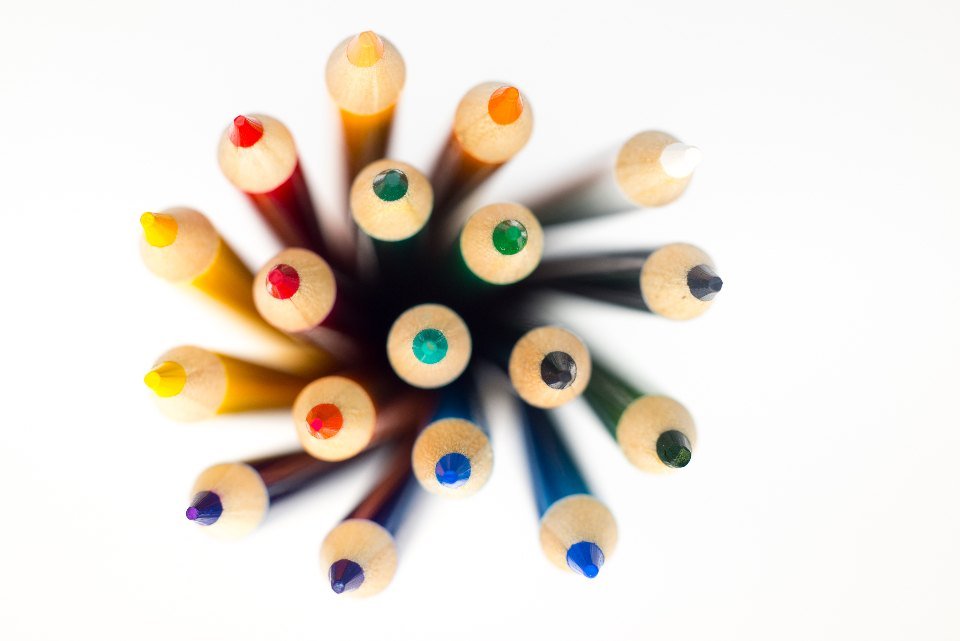 Coloured pencils arranged in a circle on a white background