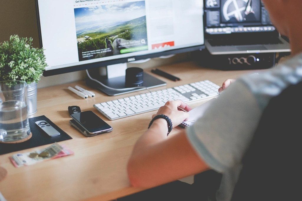 Person working at a desktop computer showing a website layout